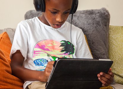 Child with headphones and tablet