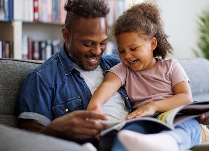 Father and daughter looking at a book together