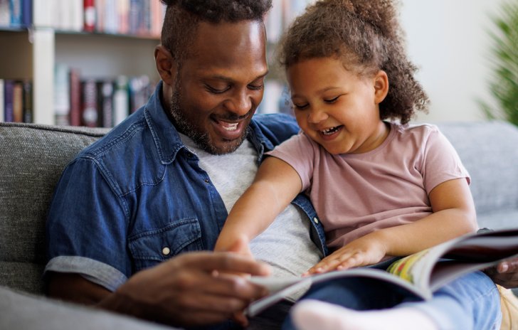 Father and daughter looking at a book together