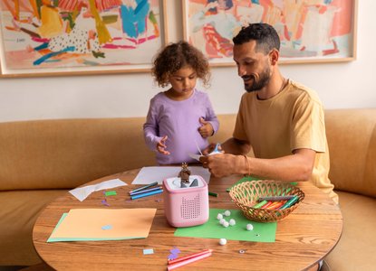 A dad and daughter play together using a Toniebox to listen to a story and be creative