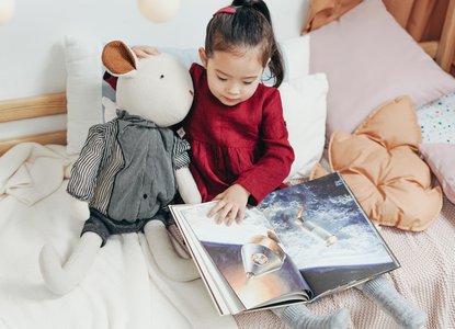 Girl reading to teddy