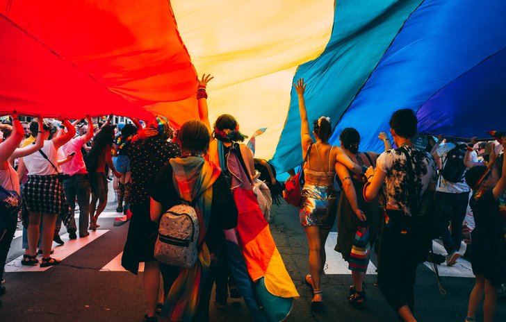 People under a Pride flag