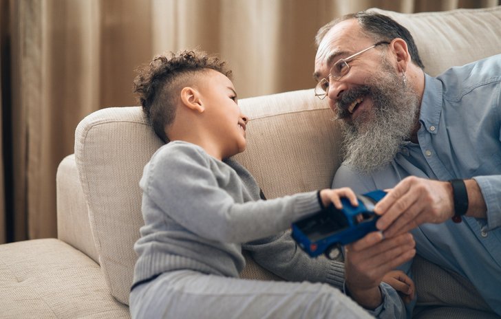 father/grandfather and boy laughing and holding a car